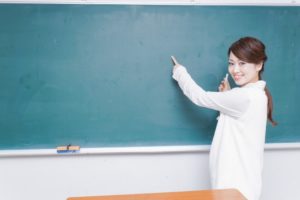 黒板で教える女性