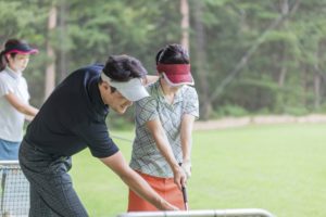 ゴルフの練習をする男女